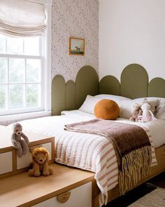 there is a bed with two teddy bears on the dressers and a window in the background