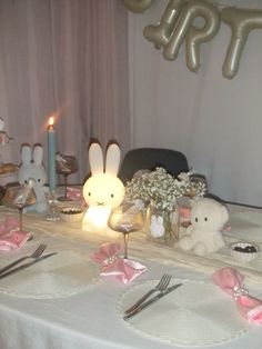 the table is set with bunny decorations and candles