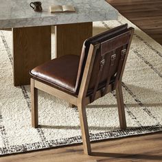 a brown leather chair sitting in front of a table