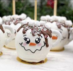 there are marshmallows that have been decorated to look like snowmen on sticks