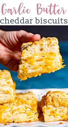 someone is holding up some cheddar biscuits to take them out of the oven