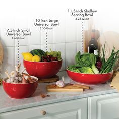 two red bowls filled with vegetables on top of a counter