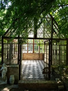 the inside of a glass house that is surrounded by trees