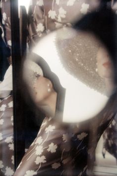 the reflection of a woman's head through a magnifying glass with flowers on it