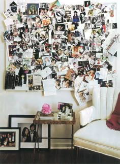 a white chair sitting in front of a wall covered with pictures