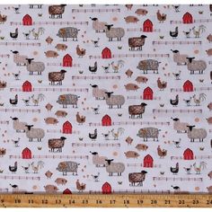 a white fabric with farm animals on it and a red barn in the background, as well as a ruler