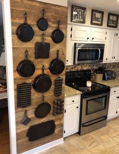 a kitchen with pots and pans hanging on the wall next to stove top oven