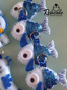 several blue and white fish keychains with sequins on them are shown