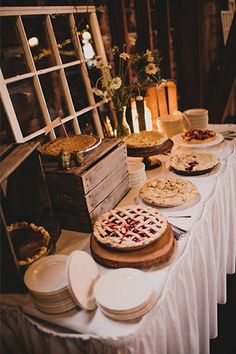 a table topped with lots of pies next to a window