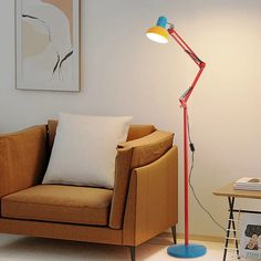 a living room with a chair, lamp and pictures on the wall