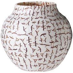 a white vase with brown designs on it