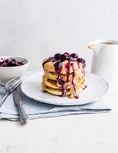 a stack of pancakes with blueberries and syrup