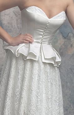 a woman wearing a white dress with a bow at the waist