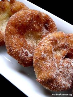 three sugared doughnuts on a white plate