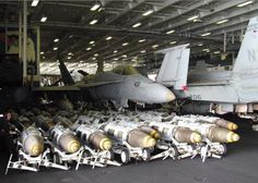 several fighter jets are on display in an aircraft hanger