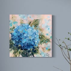 a blue flower painting on a wall next to a vase with some flowers in it