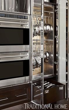 a kitchen with stainless steel ovens and cabinets in the center, including pots and pans