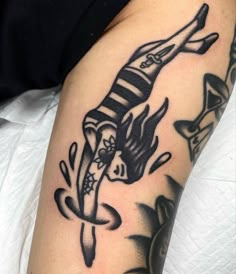 a woman's leg with a black and white tattoo design on her arm,