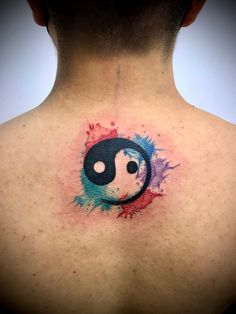 the back of a man's neck with a tattoo on it that has a yin symbol painted on it