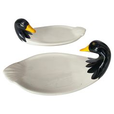 two black and white ceramic ducks sitting on top of each other