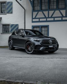 the mercedes benz amg coupe is parked in front of a white and blue building