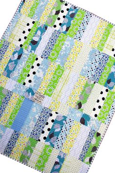 a blue and green patchwork quilt on a white background