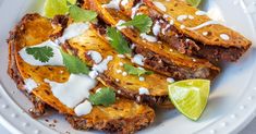 a white plate topped with food covered in sauce and garnished with cilantro