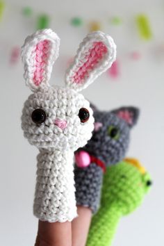 crocheted bunny finger puppets are shown in three different colors