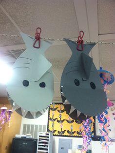 two paper shark masks hanging from the ceiling