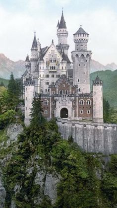 an old castle on top of a mountain with trees and mountains in the back ground