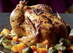 a roasted chicken with vegetables on a plate