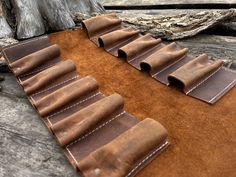 a brown leather wallet sitting on top of a wooden table next to a piece of wood