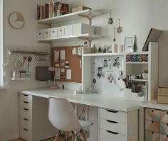 a white desk with lots of drawers and shelves on top of it in a room