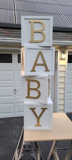 the letters are made out of wood and have gold foil on them that spell out baby