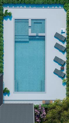 an aerial view of a swimming pool with lounge chairs and green plants on the side