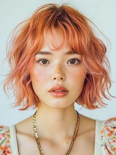 a young woman with red hair and freckled bangs wearing a flowered top