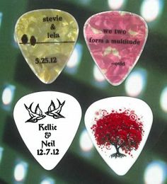 four guitar picks with different designs on them, one has a tree and the other has two