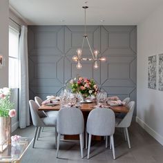 a dining room table is set with flowers and place settings for four people to eat