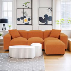 a living room with orange couches and art on the wall