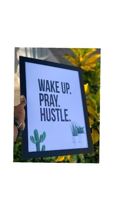 a person holding up a sign that says wake up pray hustle with cacti and succulents