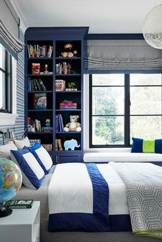 a blue and white bedroom with bookshelves