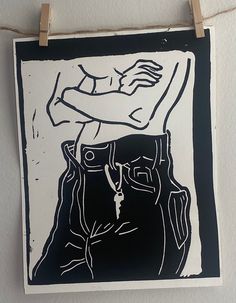 a black and white drawing hanging on a wall next to a string with clothes pins