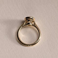 a gold ring with a diamond on the top, sitting on a sheet of paper