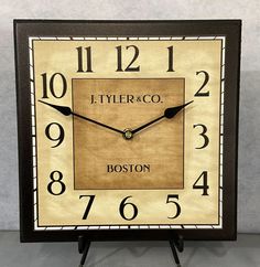 a square clock with the words,'ittymerco boston'on it