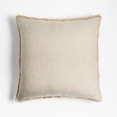 a beige pillow with fray edges on a white background, it is made from linen and has a light brown trim around the edge