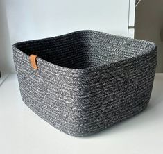 a large gray basket sitting on top of a white counter