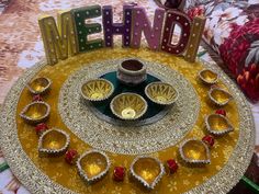 a decorated plate with diyas and the word mehne spelled out on it