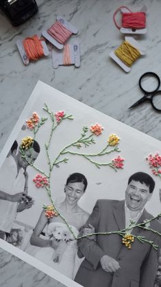 an image of two people with flowers on their heads and some yarn next to them