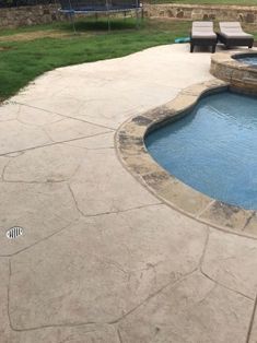 a backyard with a pool and patio furniture