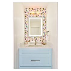 a bathroom sink with a mirror above it next to a blue cabinet and counter top